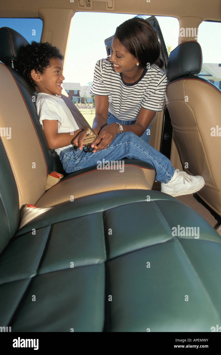 Mother buckles car seat belt for boy Stock Photo Alamy
