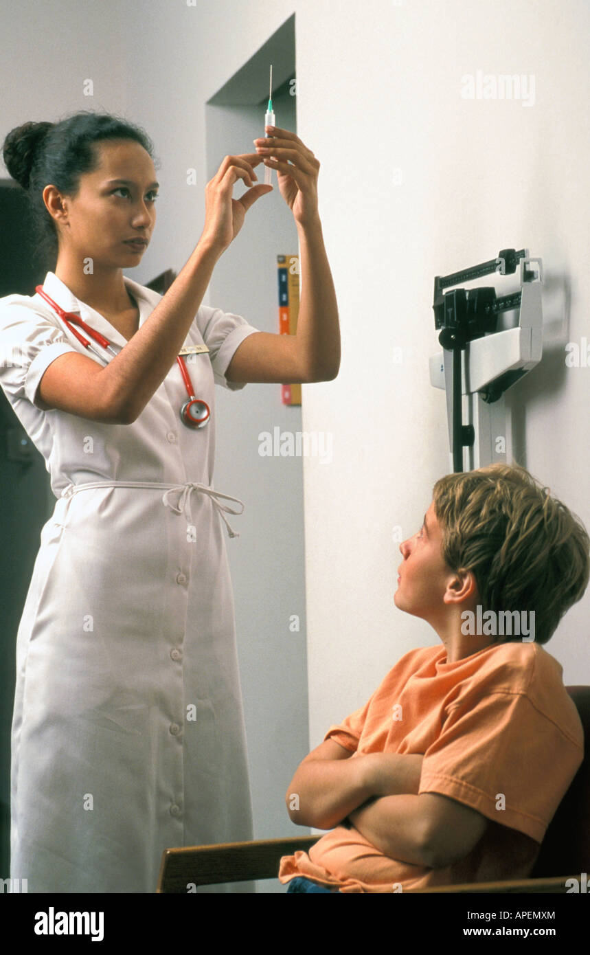 Nurse prepares to give boy a shot. Stock Photo
