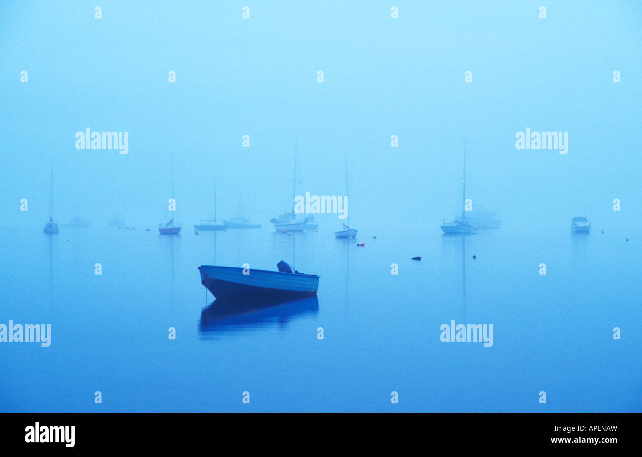 A groups of boats in a bay are surrounded by fog Stock Photo - Alamy