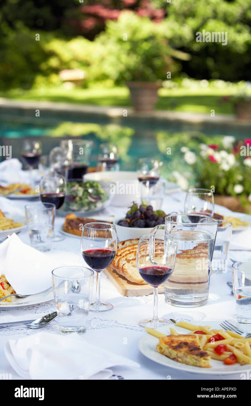 Table full of food and wine in backyard Stock Photo