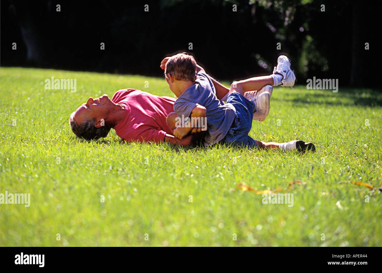 Caucasian grandfather and grandson wrestling Stock Photo