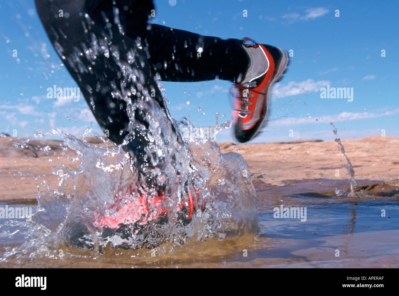 Runner splashing in puddle Stock Photo