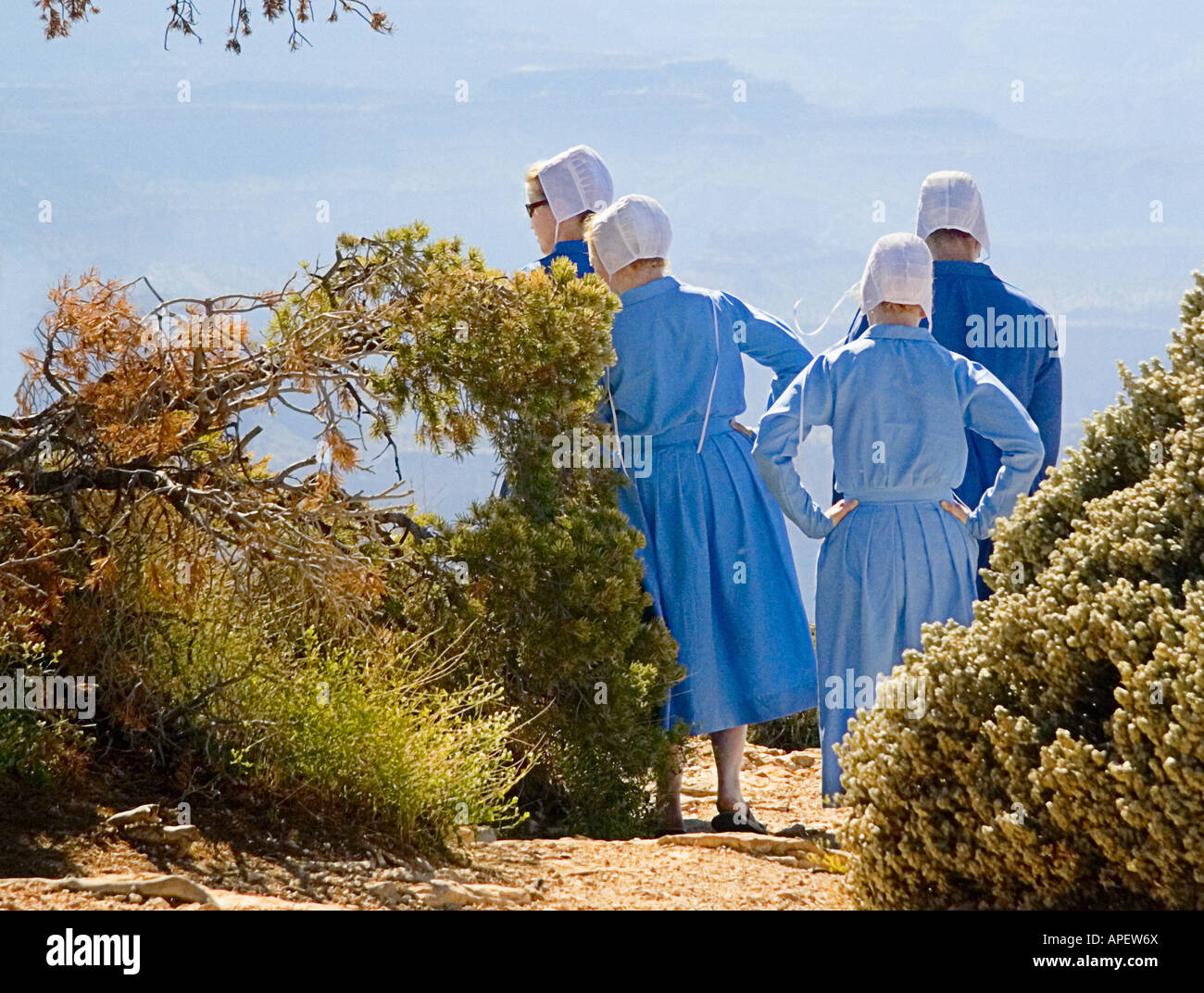 Amish girls in traditional blue dress and white hats overlooking the Grand Canyon. Stock Photo