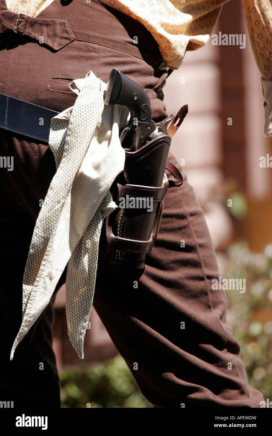 A cowboy holding a gun on his hip in his holster with a scarf at an historical wild west reenactment Stock Photo