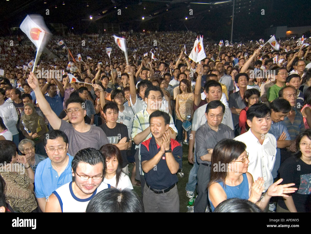 A crowd of Singaporeans cheering a gathering of the Workers Party in ...