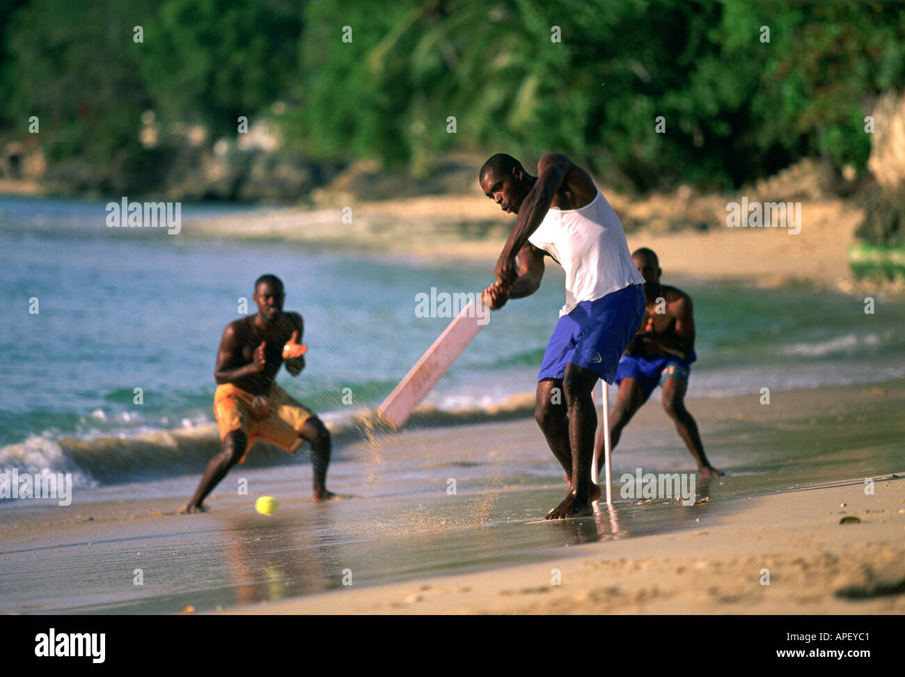 Cricket players on wet sand,  Bahamas Stock Photo
