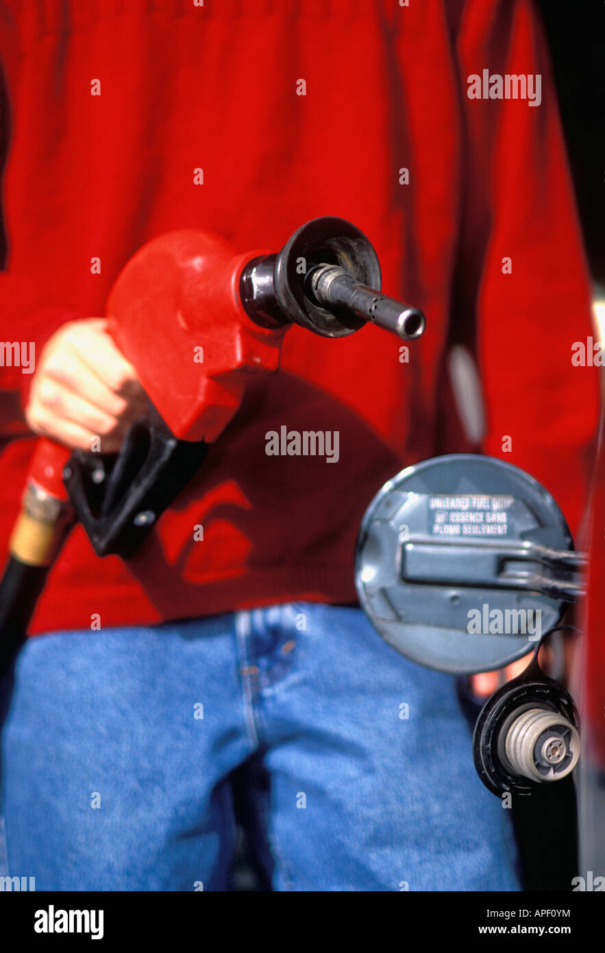 Close up of Man Putting Gas Pump Nozzle into Vehicle Gas Tank Indiana Stock Photo