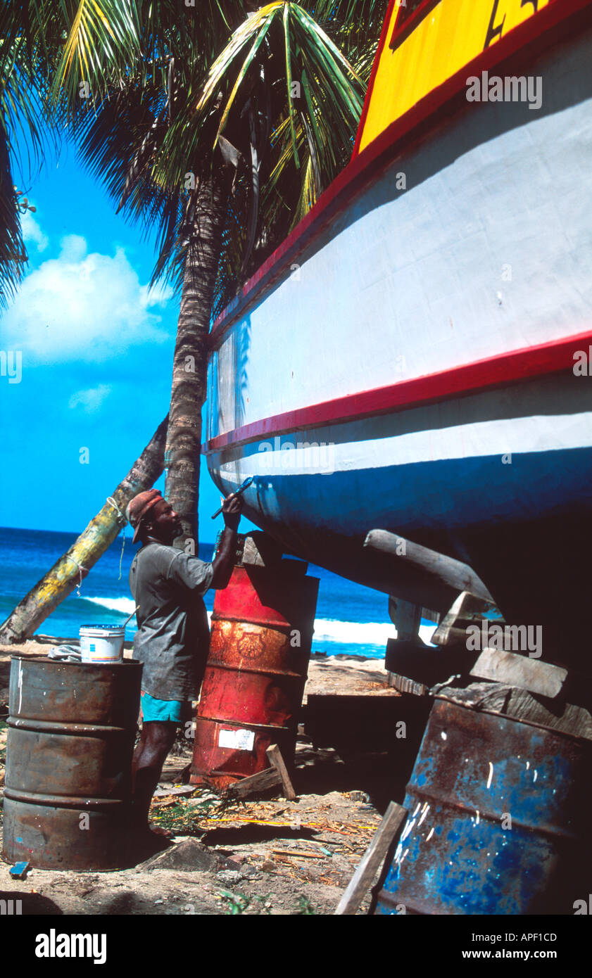 Man painting his fishing boat Barbados Stock Photo