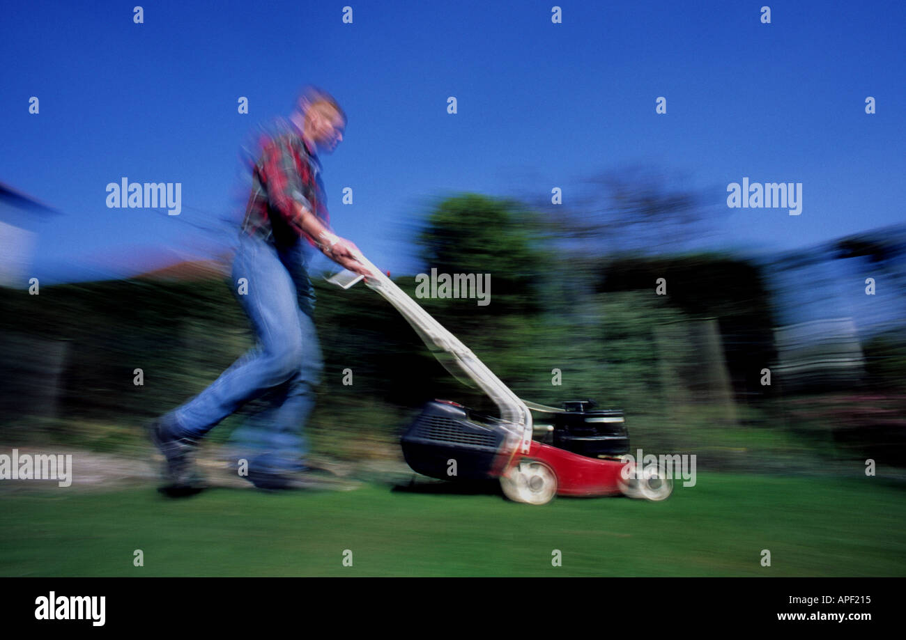man mowing garden lawn on summer day uk Stock Photo