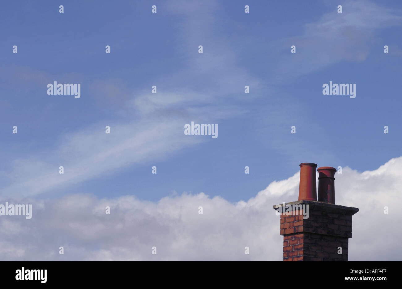 Single red brick chimney against blue sky with clouds Stock Photo - Alamy