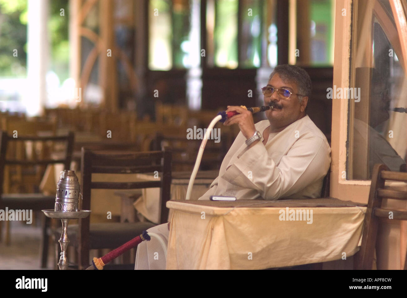 Man Smoking water pipe in Alexandria Egypt coffee shop street side cafe Stock Photo