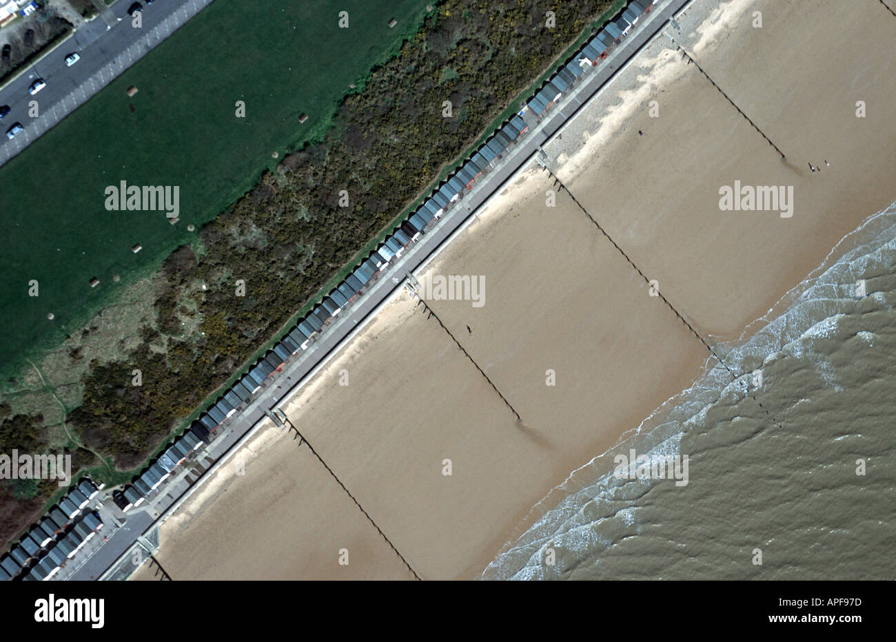 Kent coast with sandy beach beach huts and groynes Stock Photo