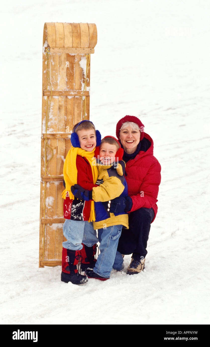 Grandma and grandsons standing with toboggan Stock Photo