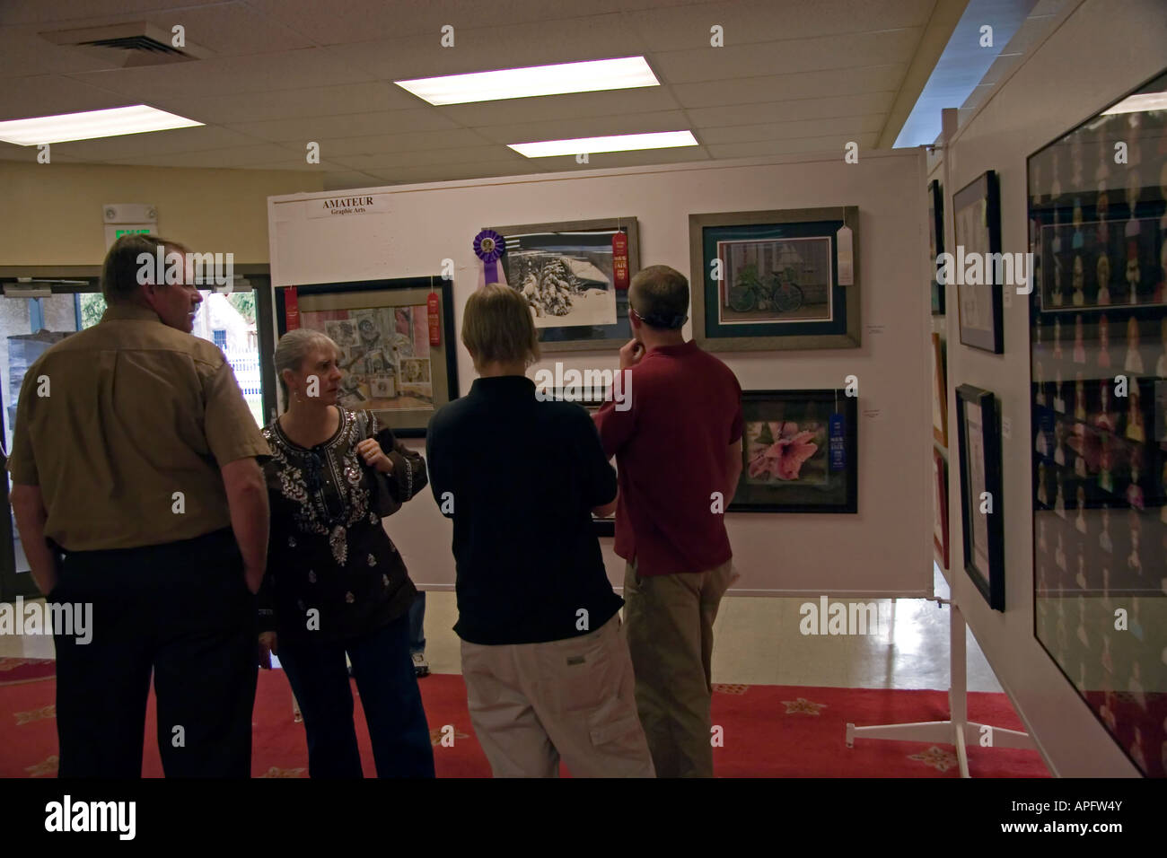 A family stops to appreciate the many works of art on display at this Art Exhibit at the Utah State Fair in SLC, Utah, USA. Stock Photo