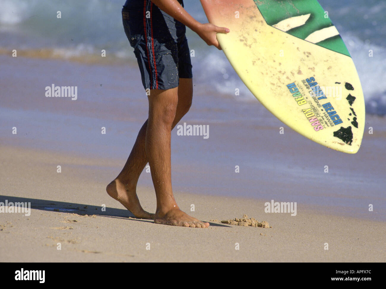 Man holding skim board at waters edge, Hawaii, USA Stock Photo