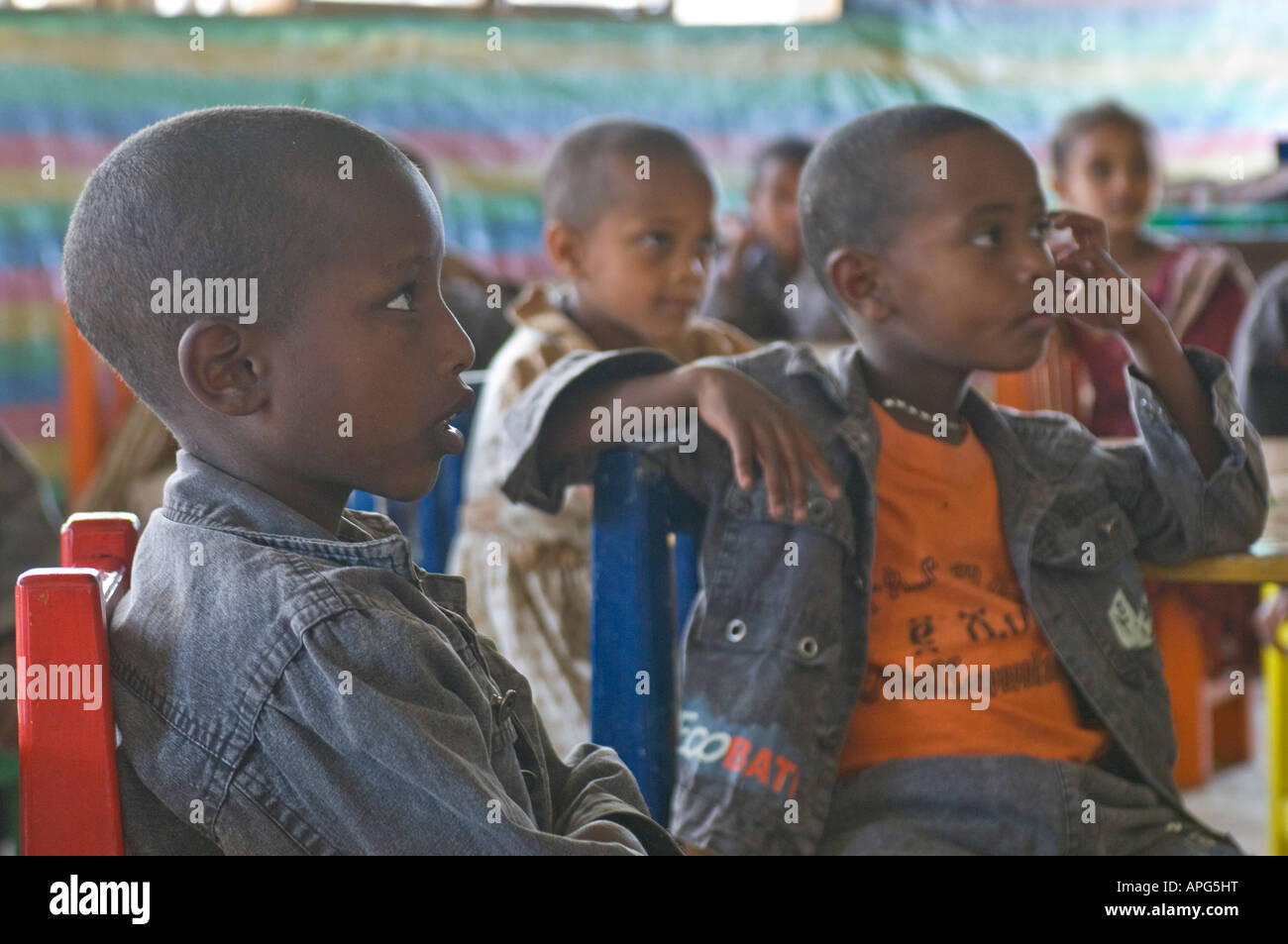 Children listen intently in the classroom of a charity run school. Stock Photo