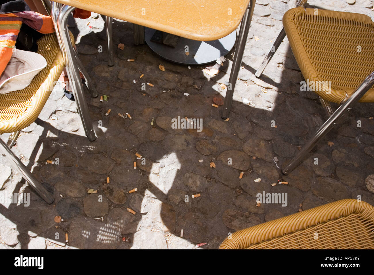Cigarette butts underneath a cafe table Stock Photo - Alamy