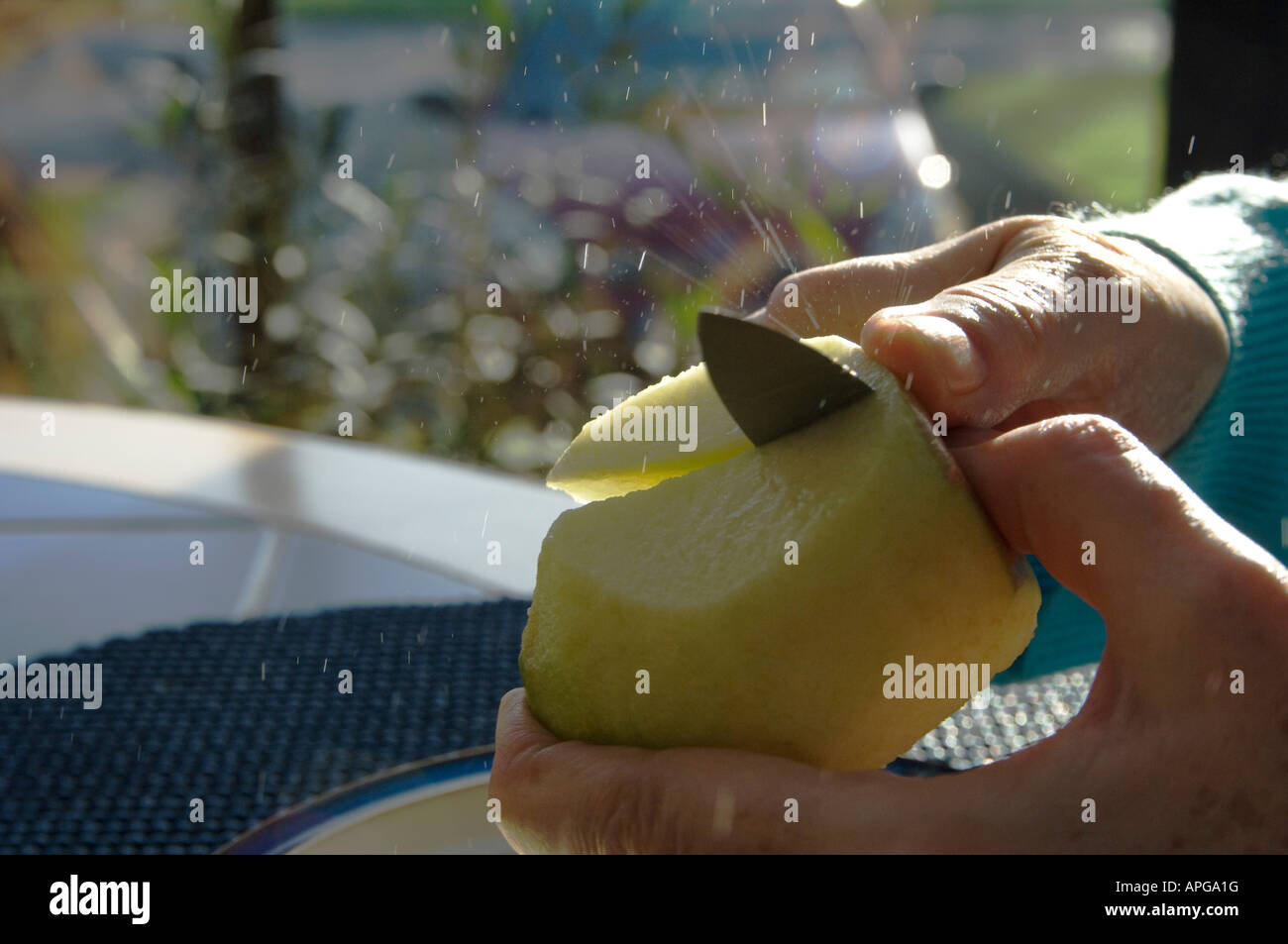 Splashing juices as an apple is being cut Stock Photo