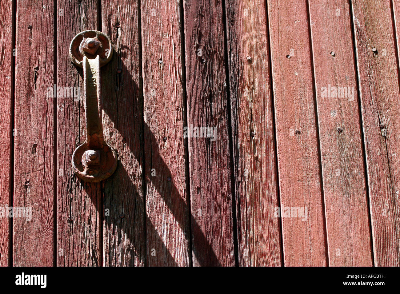 Old weathered wooden red door with metal handle on a freight train railcar or boxcar Stock Photo