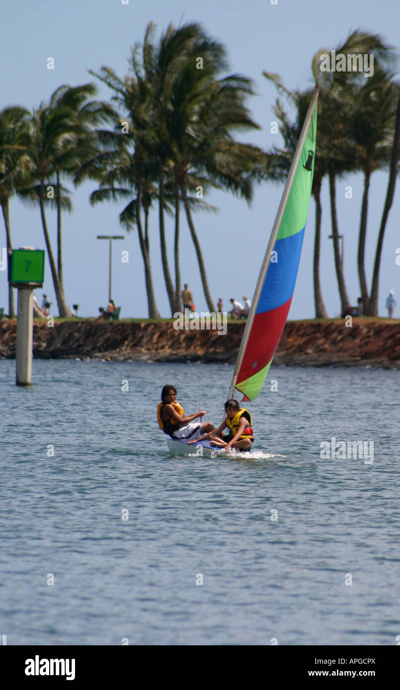 Two children sailing a Topper sailboat in the Ala Wai Boat Harbor