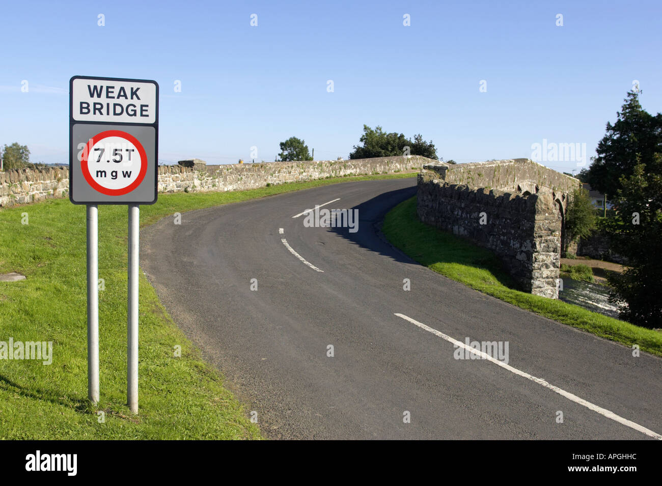 weak bridge 7 5 tonnes mgw weight restriction road sign and road leading over old stone bridge Stock Photo