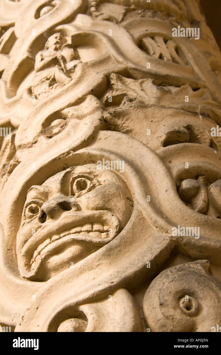 Detail of carved pillar with astrological symbols and grimmacing face Stock Photo