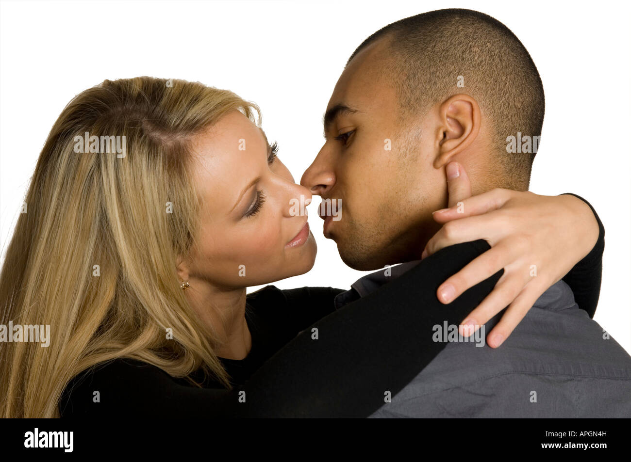 mixed race couple cuddling looking into each others eyes about to kiss Stock Photo