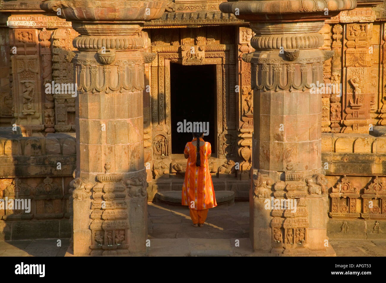 Indian woman praying at Mukteswar Mandir with with ornate carving Bhubaneswar Orissa India Stock Photo