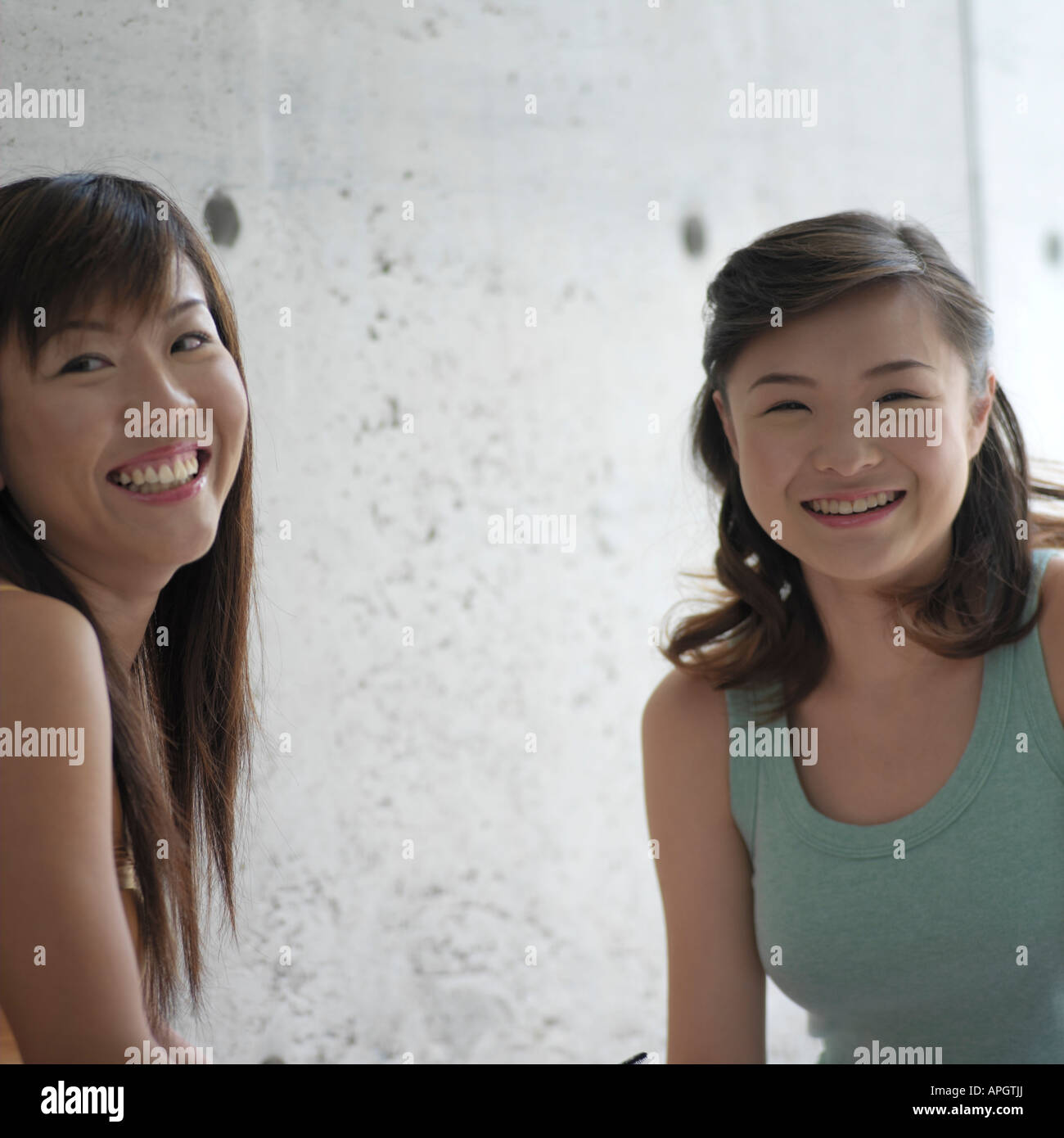 Portrait of two young women smiling Stock Photo - Alamy