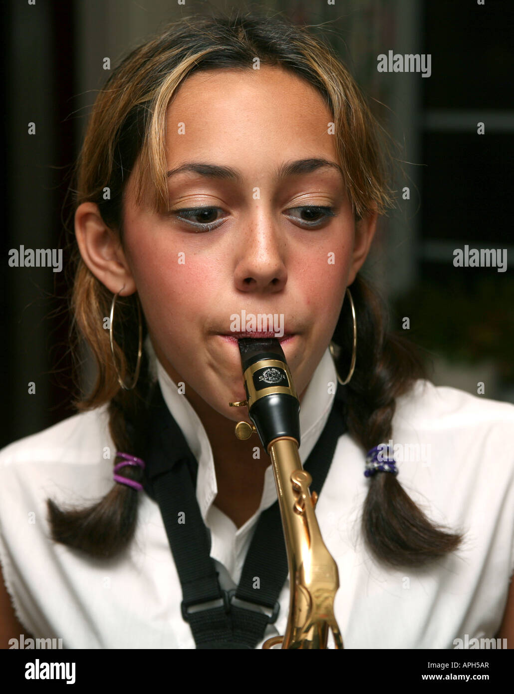 A teenage girl plays the saxophone Stock Photo