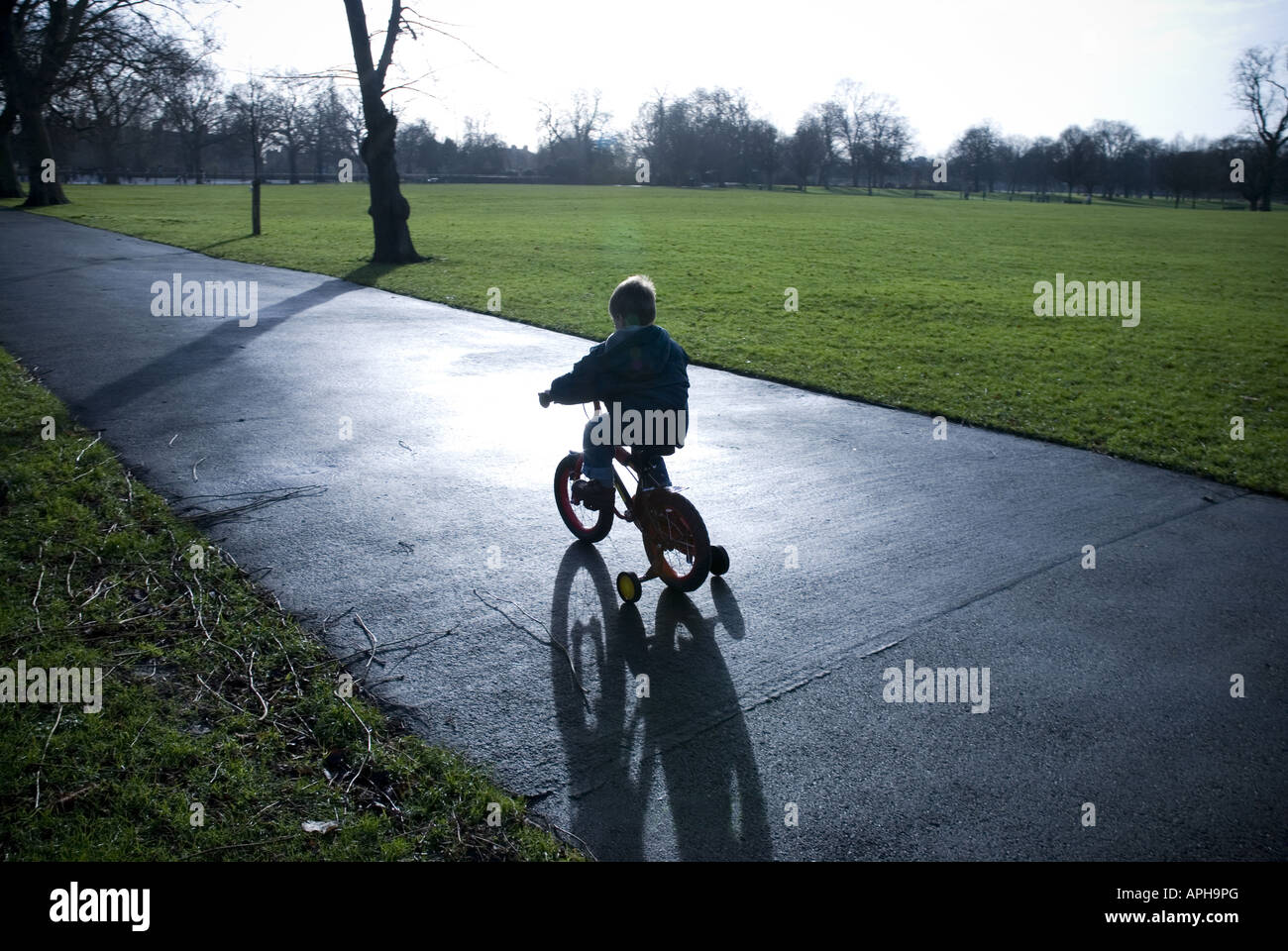 Kid on bicycle with stabilizers Stock Photo