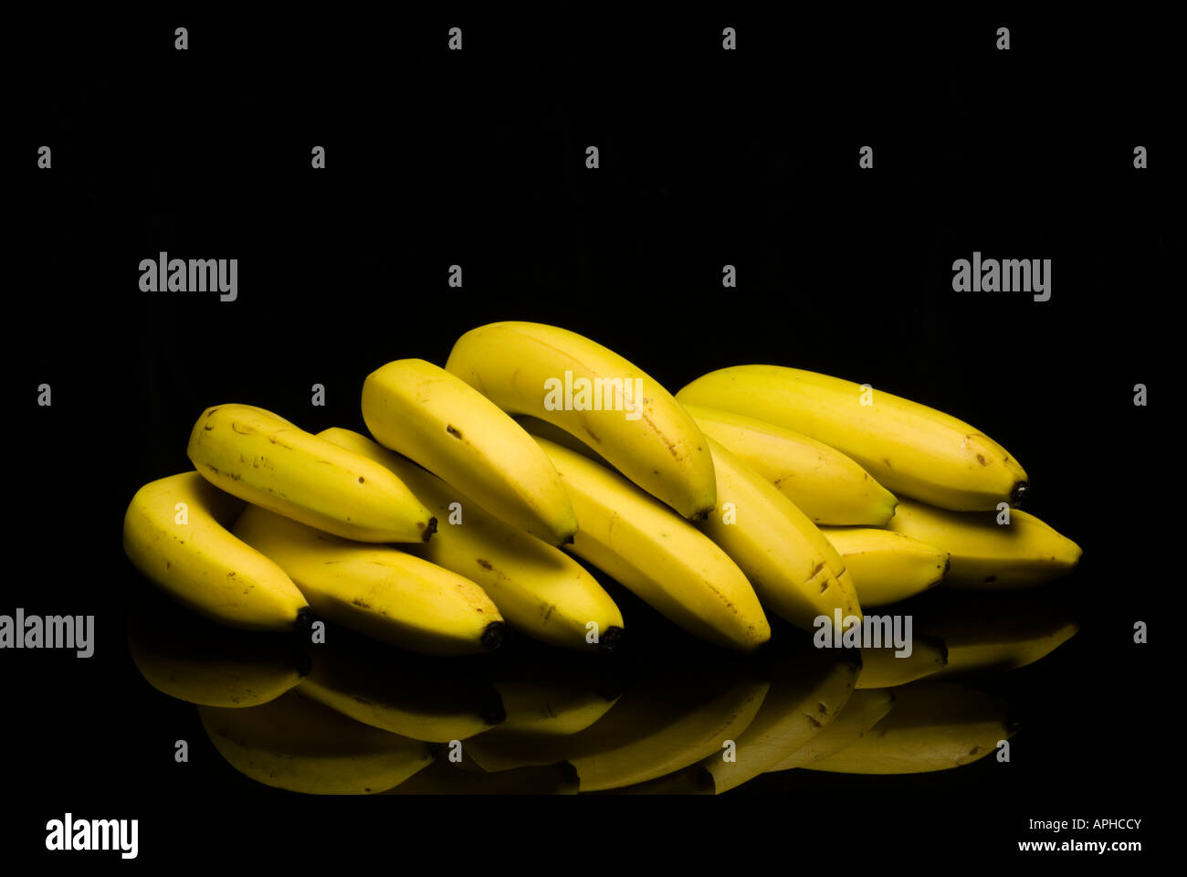 Landscape image showing three bunches of ripened Free Trade bananas on a black background Stock Photo