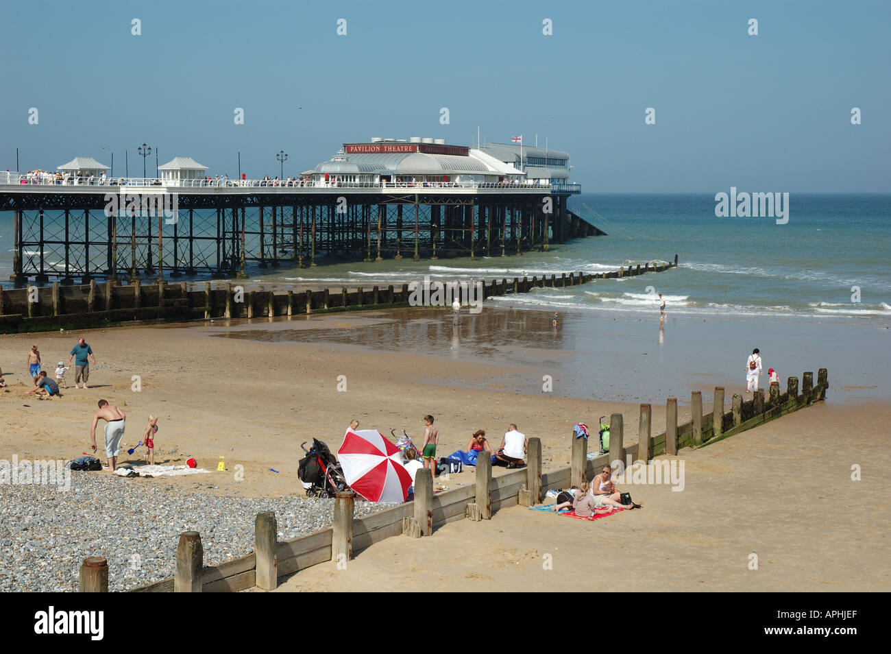 Uk, Norfolk, Cromer, people on beach with pier and Pavilion Theatre Stock Photo