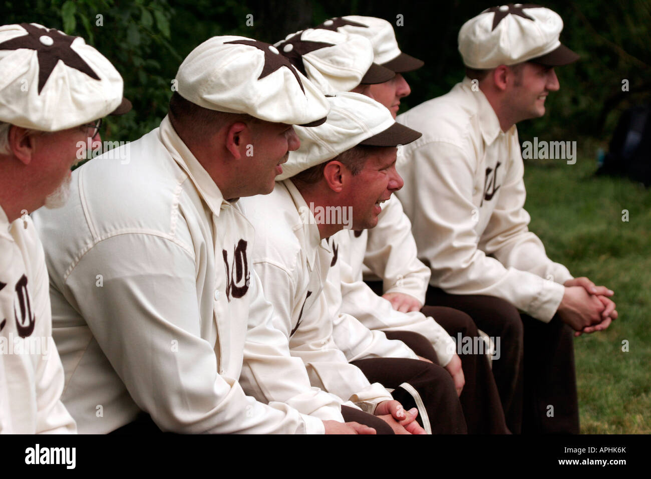 Baseball players sitting on the bench at a vintage baseball game being