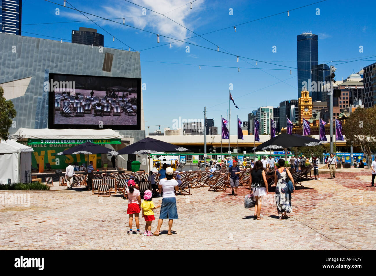 Melbourne Cityscape / Cricket fans enjoy a live telecast of cricket in Melbourne`s Federation Square, Victoria Australia Stock Photo