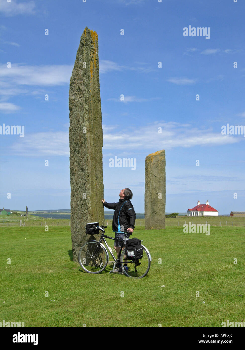 Cyclist on Orkney looking at the standing stones at Stenness Orkney Stock Photo