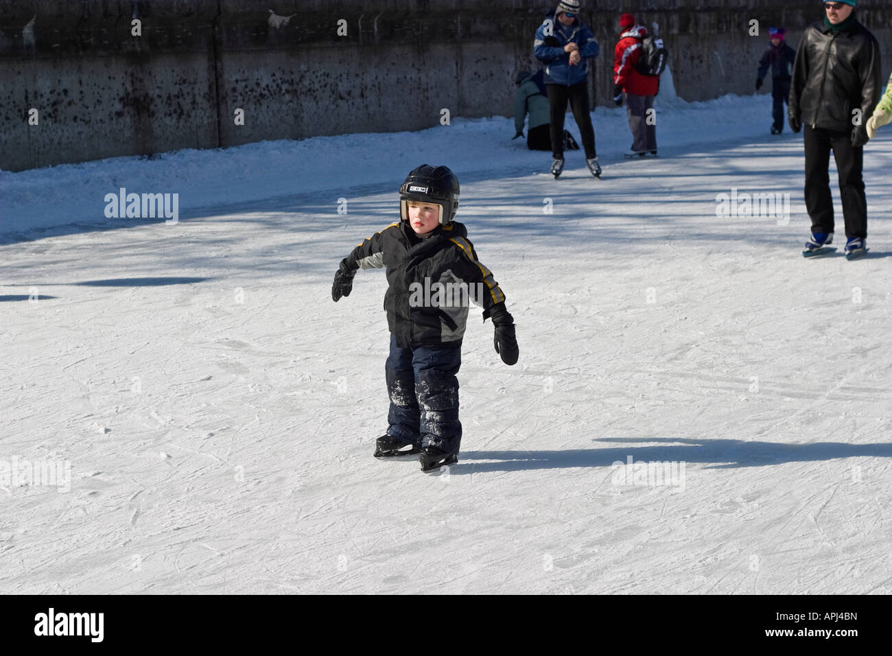 Little boy in protective gear ice skating Stock Photo Alamy