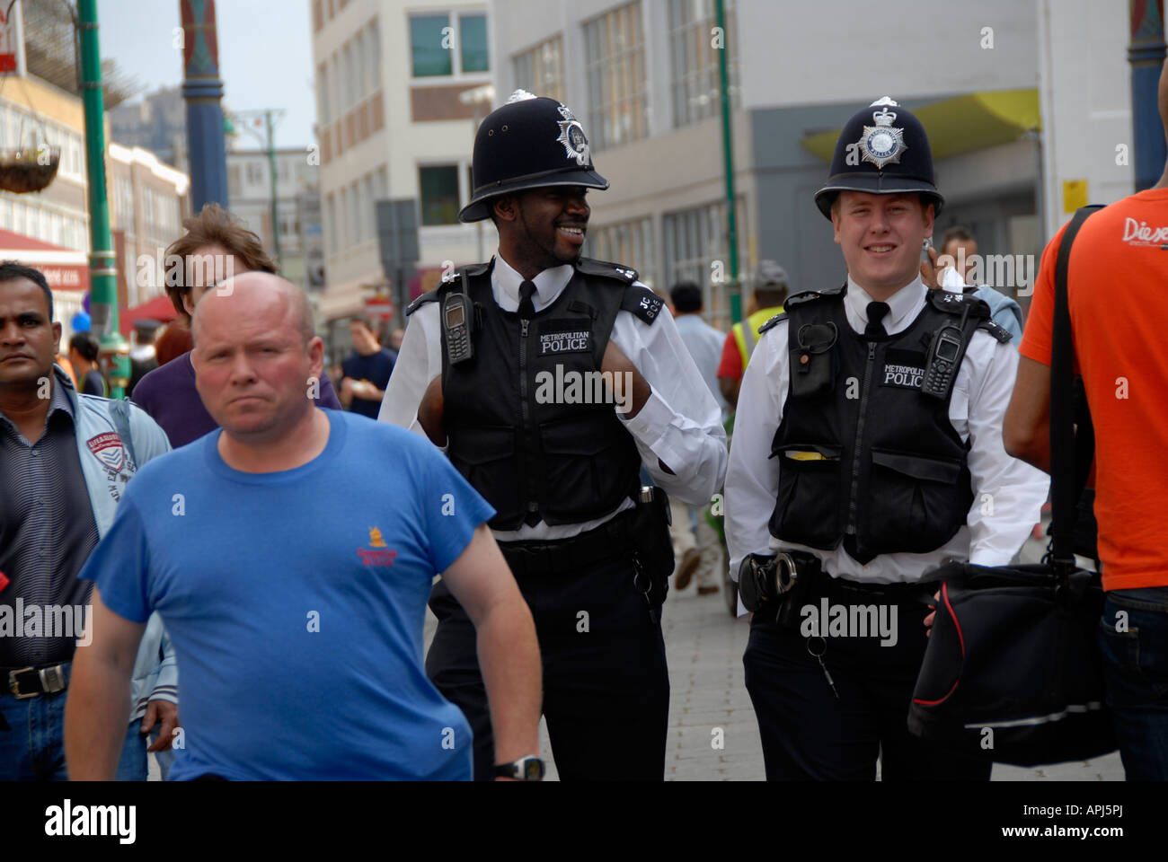 Brick lane on a busy Sunday with police and multiethnic crowd. Stock Photo