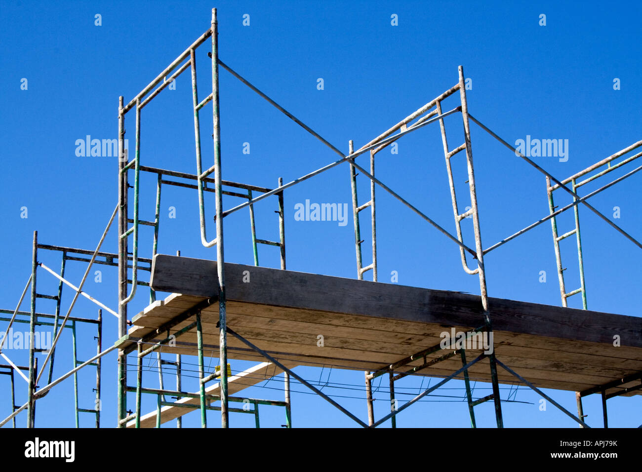 Metal construction scaffold and walkway against a blue sky. Stock Photo