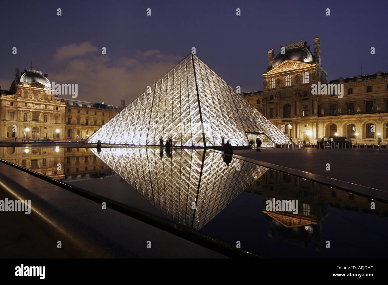 Le Louvre museum Pyramid Paris at night Stock Photo