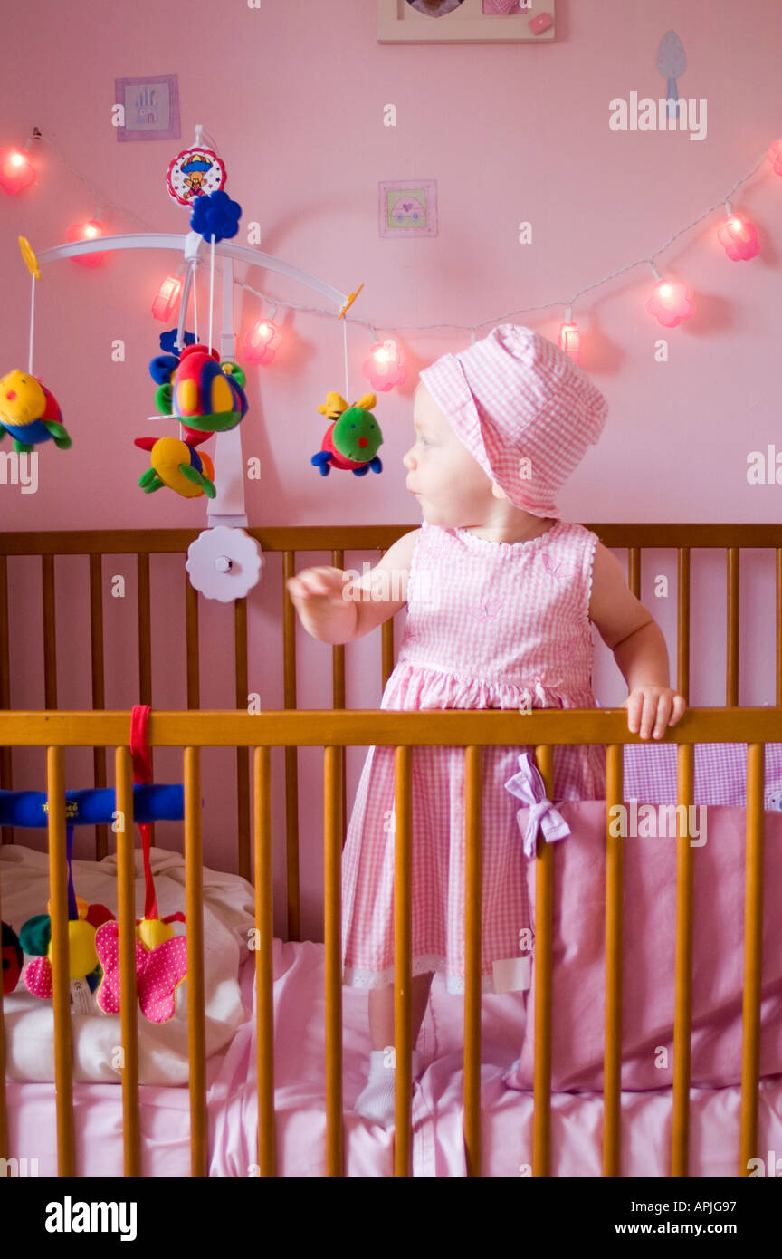 Baby in cot and bedroom Stock Photo