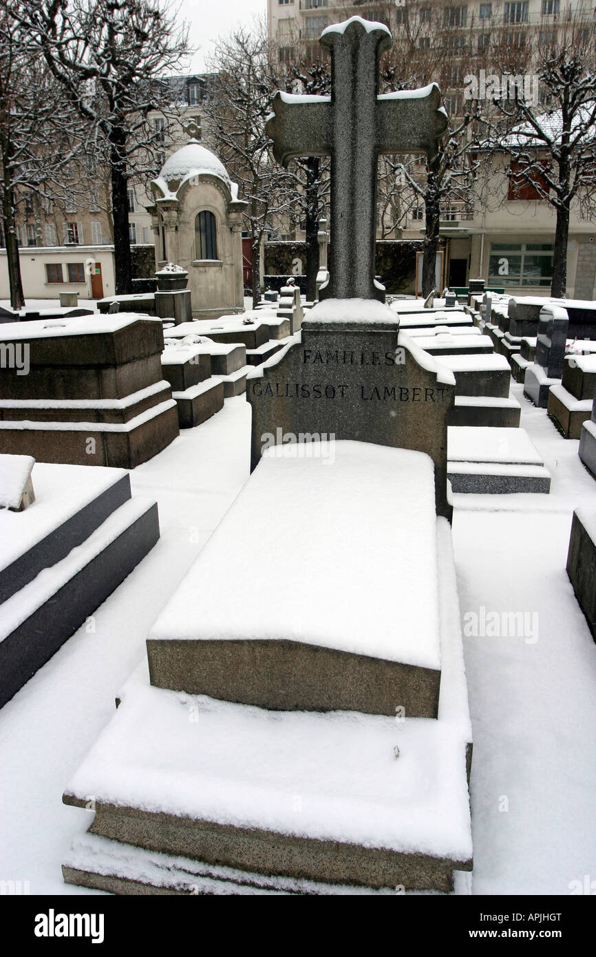 A tombstone in the snow Grenelle Cemetery rue St Charles Paris 15th France Stock Photo