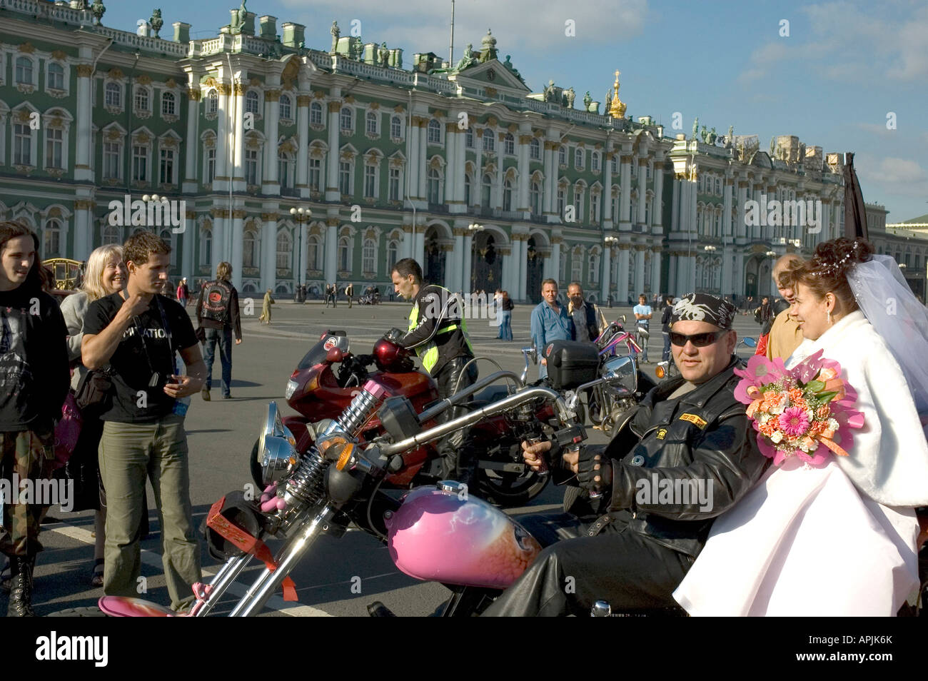 Bride and groom from a group of bikers on the Dvortsovaya Square with Hermitage Museum in background Saint Petersburg Russia Stock Photo