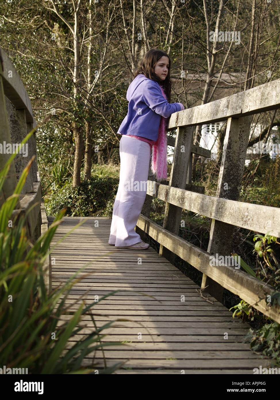 Young girl standing on a wooden footbridge Stock Photo