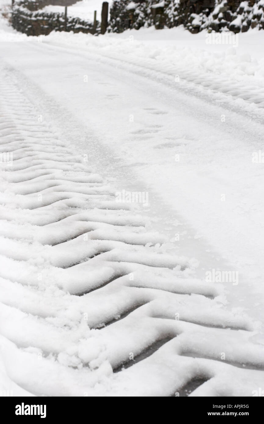 PEAT LANE, BEWERLEY, NIDDERDALE, N YORKS. 14th March 2006. After a snowfall, farmers leave tractor tyre tread pattern in snow as they feed sheep Stock Photo