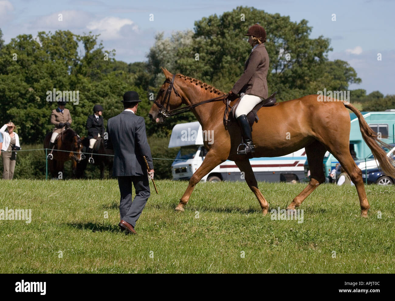 JUDGE IN BOWLER HAT JUDGING A HORSE AND RIDER AT AN EVENT IN THE UK
