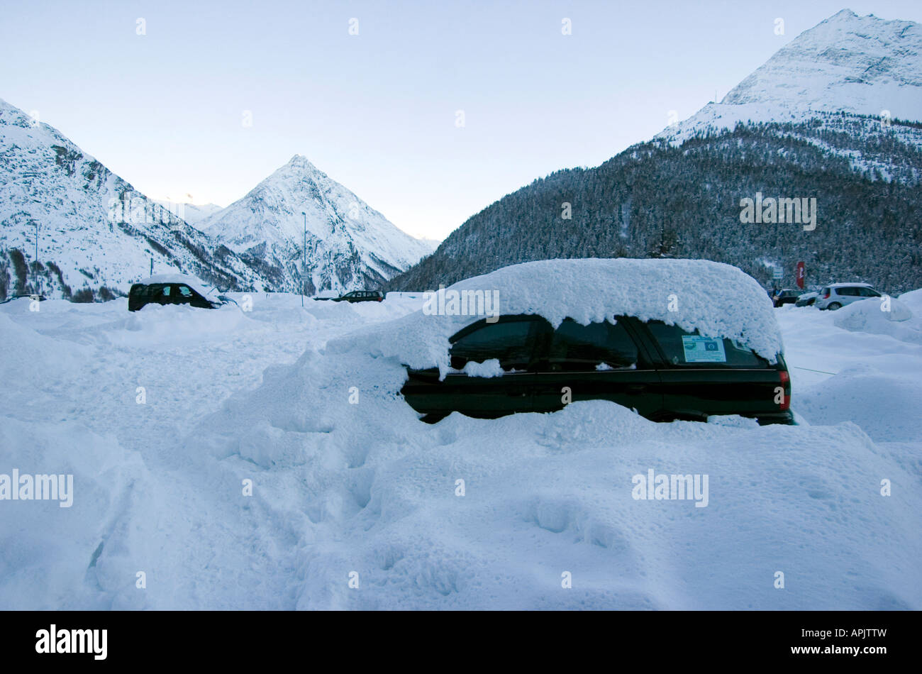 Cars covered in snow in the main car park outside the car free village of Saas Fee in the Wallis mountain range in Switzerland Stock Photo