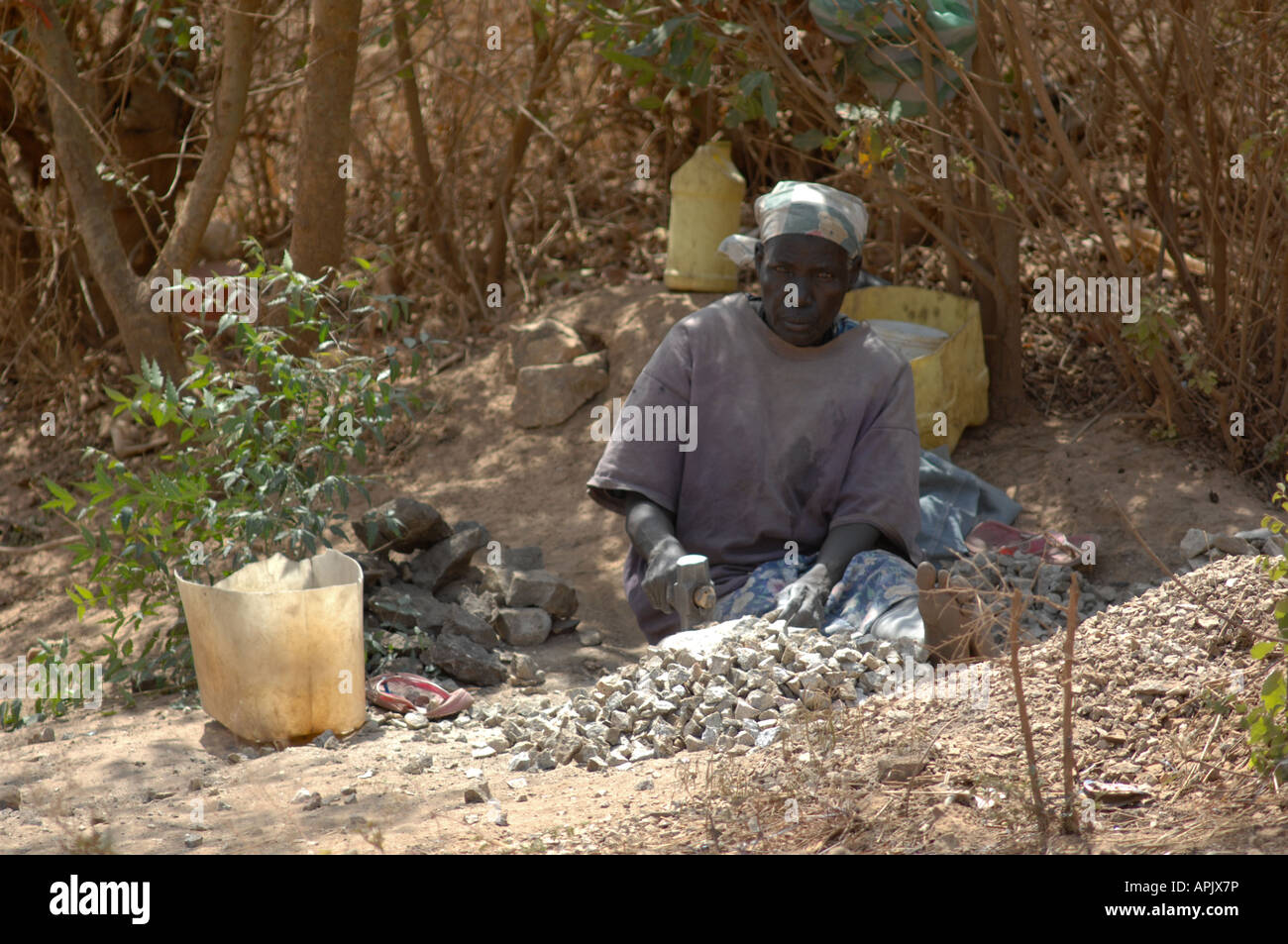 Sudanese woman breaking stones for a new road Stock Photo