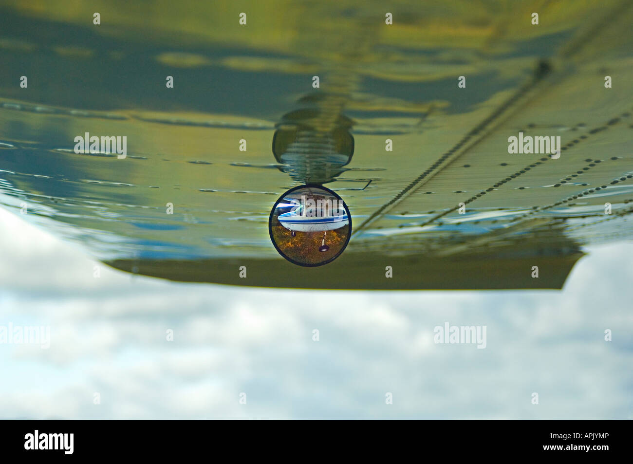 An image of under an airplane wing focusing on the mirror reflection Stock Photo