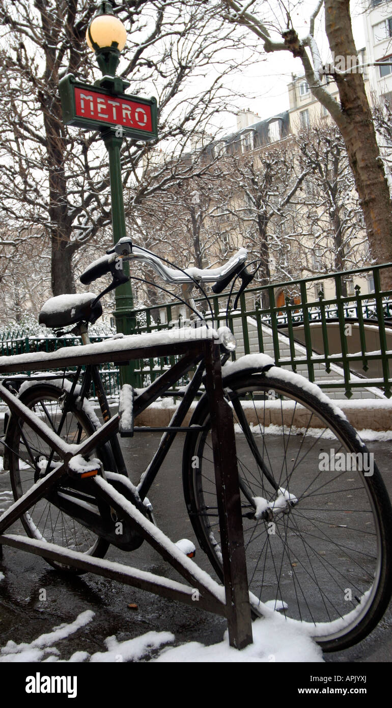 A bicycle in the snow outside the metro station Commerce Paris 15e France Stock Photo